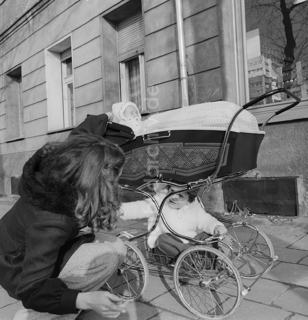 Berlin: Junge Mutter mit Kinderwagen beim Spaziergang in Berlin