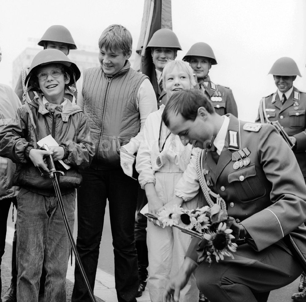 Berlin: Junge Pioniere überreichen Soldaten der NVA Blumen und Halstücher in Berlin, der ehemaligen Hauptstadt der DDR, Deutsche Demokratische Republik