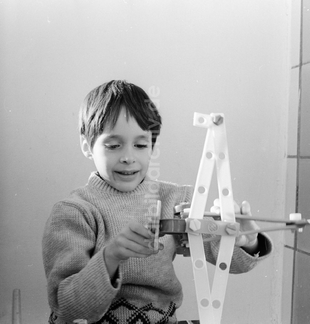 DDR-Fotoarchiv: Berlin - Junge spielt mit einem Plastik Flugzeug in Berlin, der ehemaligen Hauptstadt der DDR, Deutsche Demokratische Republik