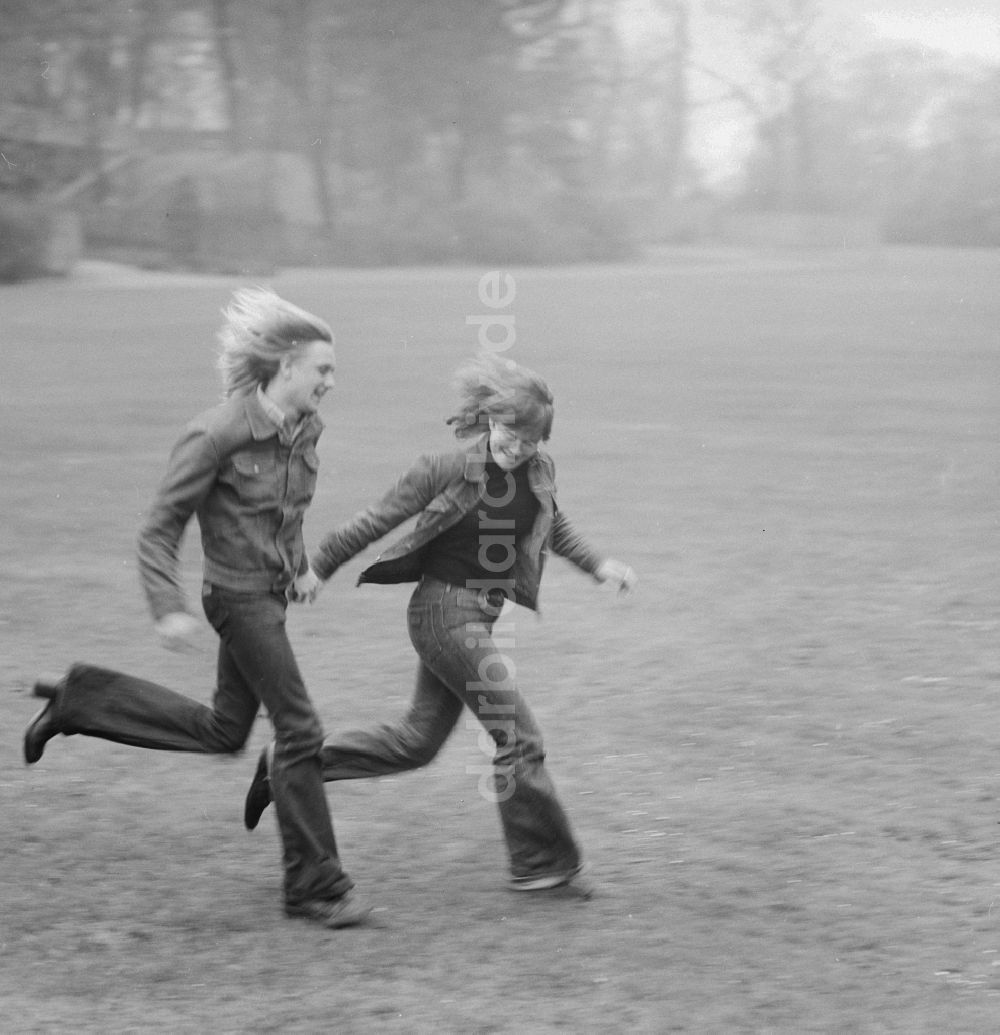 DDR-Fotoarchiv: Berlin - Junges Paar rennt über eine Wiese in Berlin