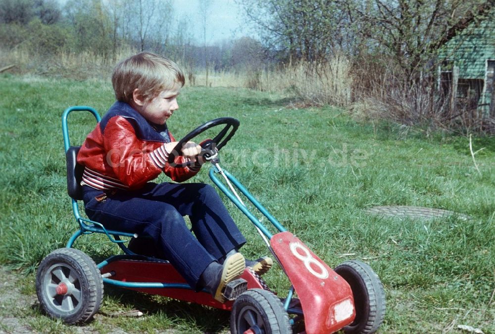 DDR-Bildarchiv: Neustrelitz - Kind mit einem Tretauto Kettcar in Neustrelitz in Mecklenburg-Vorpommern in der DDR