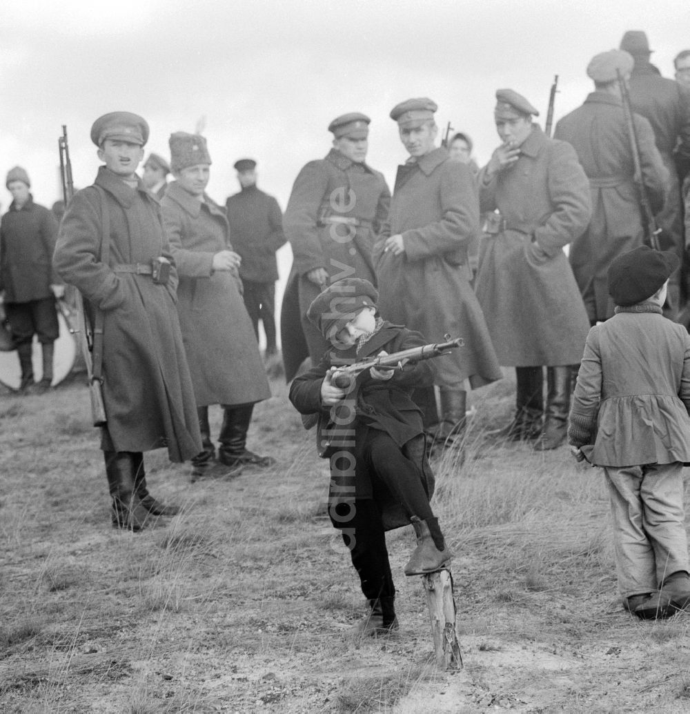 DDR-Bildarchiv: Potsdam - Kind spielt mit einem Gewehr während der Dreharbeiten zu dem Spielfilm Unterwegs zu Lenin in Potsdam in Brandenburg in der DDR