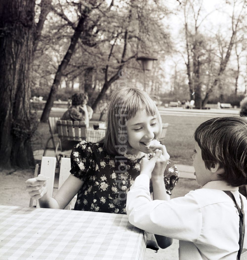 Berlin: Kinder beim Eis essen in einer Freiluft Gaststätte in Berlin, der ehemaligen Hauptstadt der DDR, Deutsche Demokratische Republik