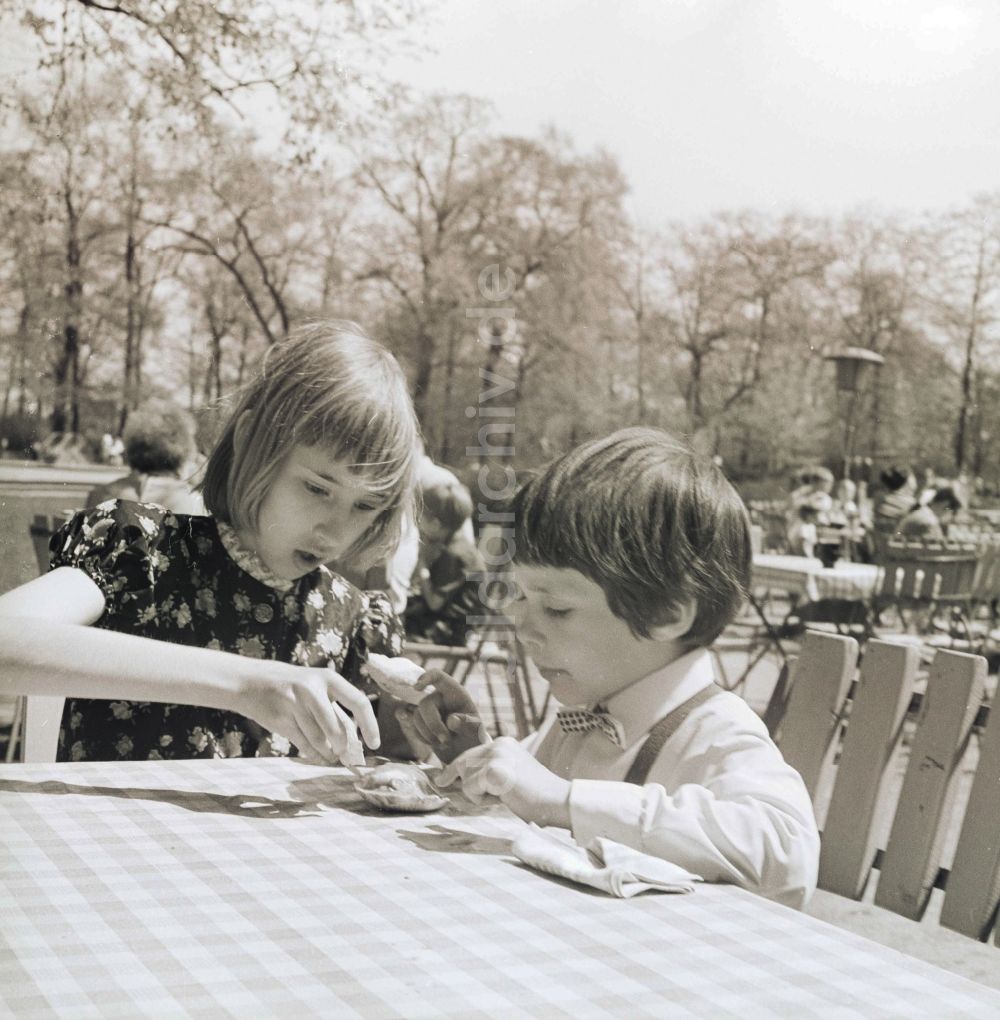 DDR-Fotoarchiv: Berlin - Kinder beim Eis essen in einer Freiluft Gaststätte in Berlin, der ehemaligen Hauptstadt der DDR, Deutsche Demokratische Republik