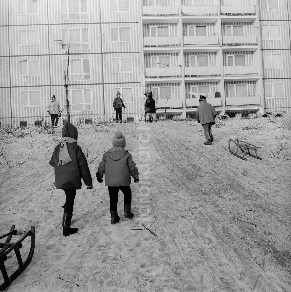 DDR-Bildarchiv: Berlin - Kinder mit Schlitten auf einem Rodelberg in einem Wohngebiet in Berlin, der ehemaligen Hauptstadt der DDR, Deutsche Demokratische Republik