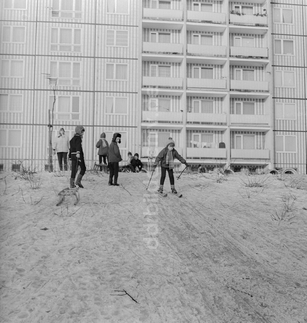 Berlin: Kinder mit Schlitten und Skiern auf einem Rodelberg in einem Wohngebiet in Berlin, der ehemaligen Hauptstadt der DDR, Deutsche Demokratische Republik