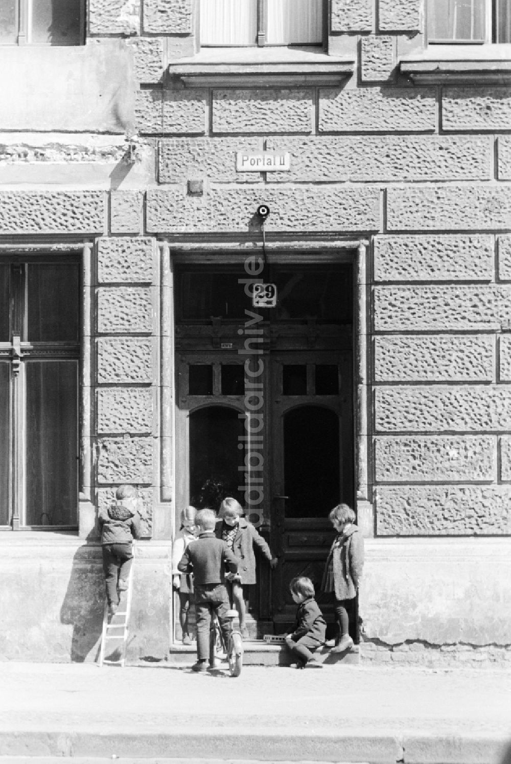 DDR-Fotoarchiv: Berlin - Kinder spielen vor einem Hauseingang eines Altbaus in Berlin, der ehemaligen Hauptstadt der DDR, Deutsche Demokratische Republik