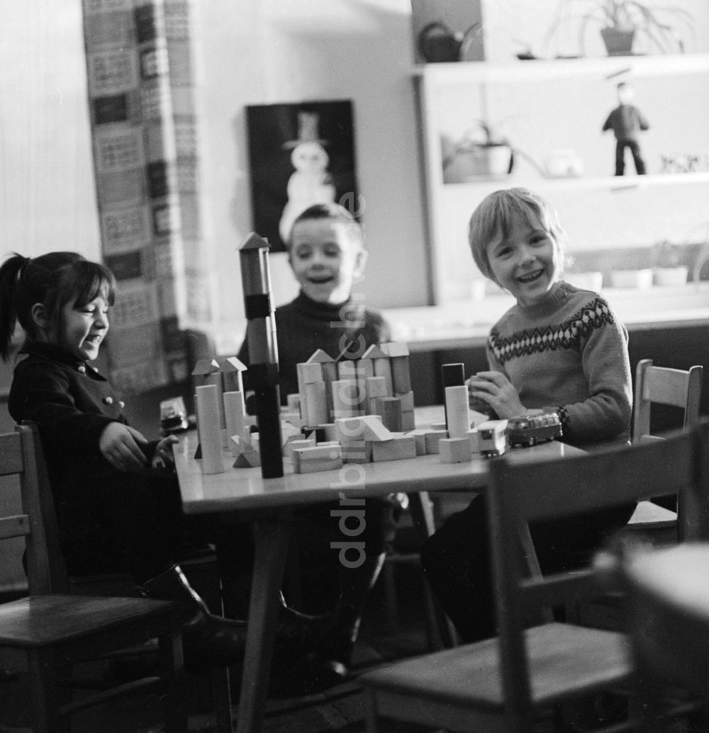 DDR-Bildarchiv: Berlin - Kinder spielen mit Holzbausteinen auf einem Tisch in Berlin