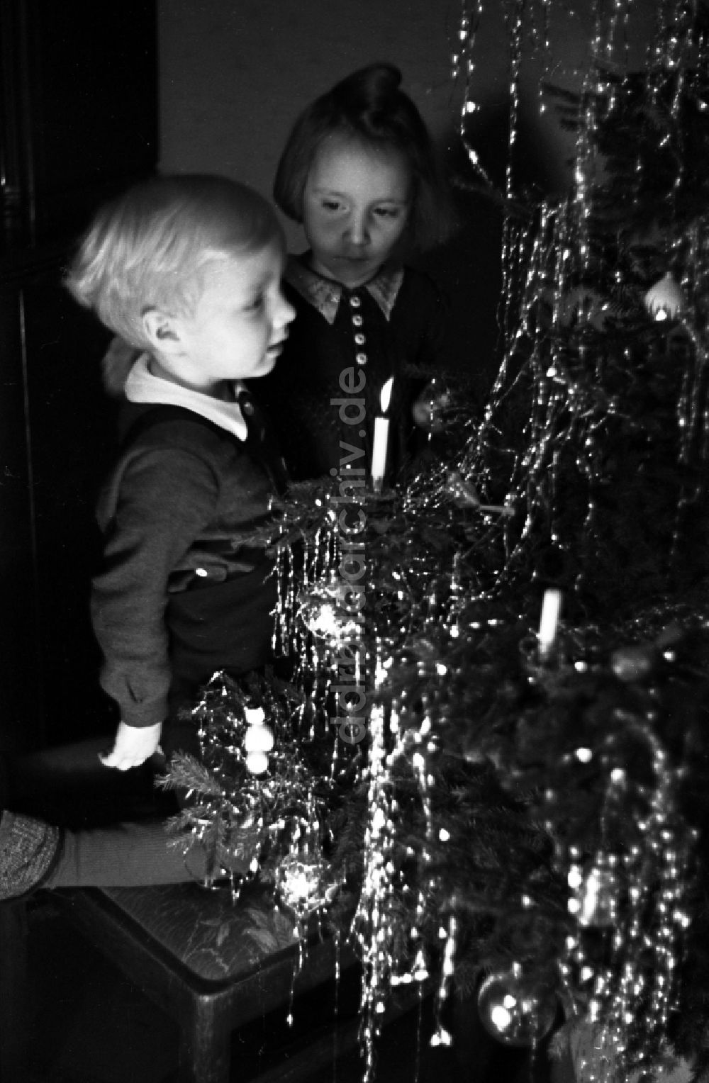 DDR-Bildarchiv: Merseburg - Kinder stehen strahlend vorm Weihnachtsbaum in Merseburg im Bundesland Sachsen-Anhalt in Deutschland