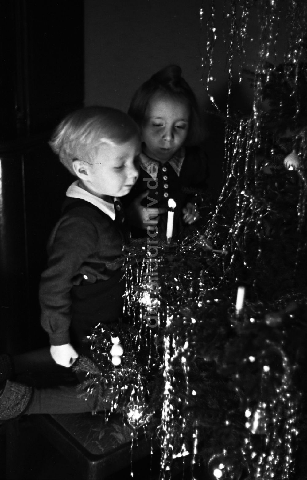 DDR-Fotoarchiv: Merseburg - Kinder stehen strahlend vorm Weihnachtsbaum in Merseburg im Bundesland Sachsen-Anhalt in Deutschland