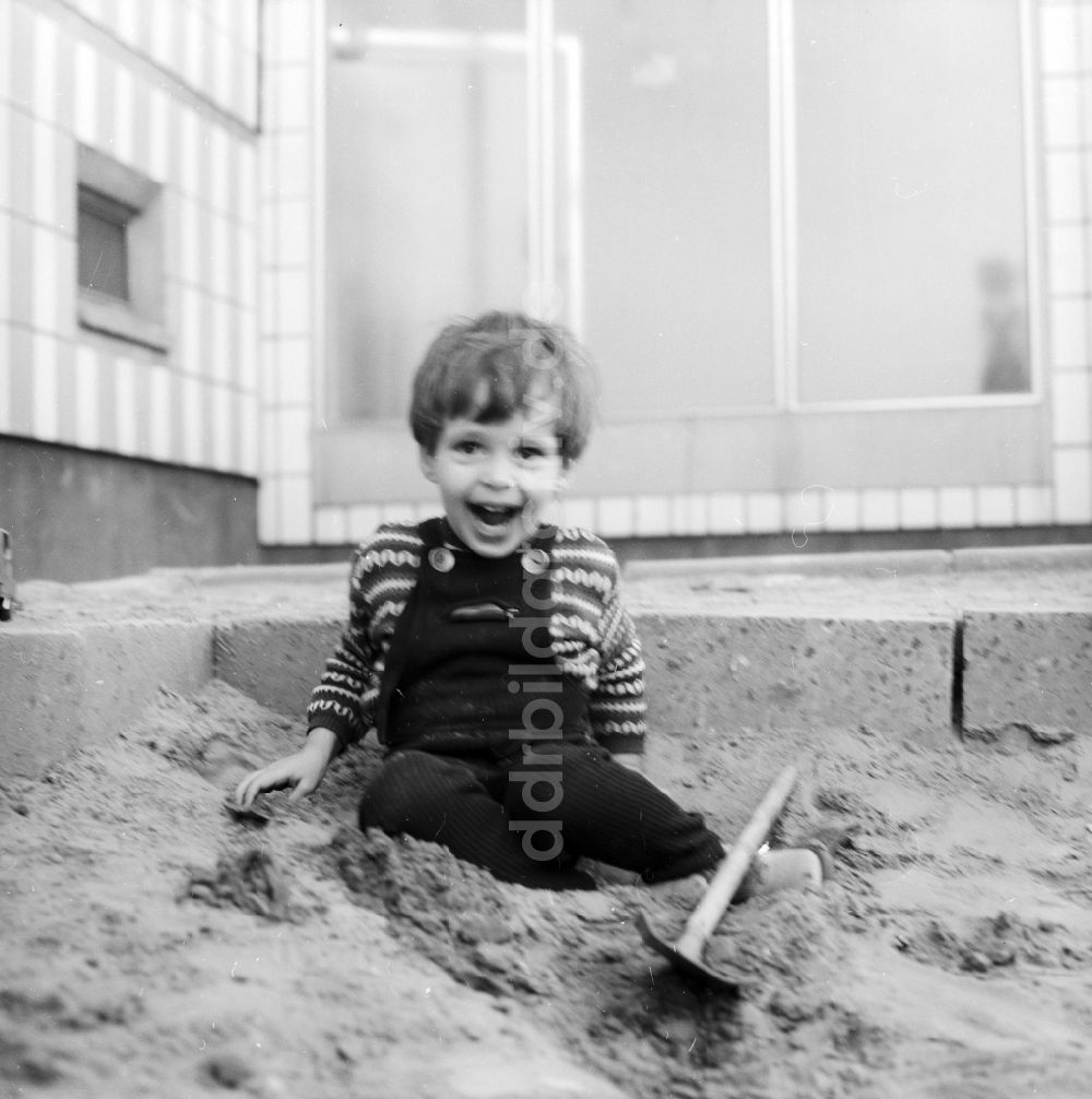 DDR-Fotoarchiv: Berlin - Kleiner Junge spielt im Sandkasten in Berlin, der ehemaligen Hauptstadt der DDR, Deutsche Demokratische Republik