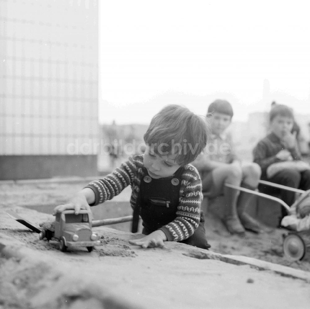 Berlin: Kleiner Junge spielt im Sandkasten mit einem Spielzeugauto in Berlin, der ehemaligen Hauptstadt der DDR, Deutsche Demokratische Republik