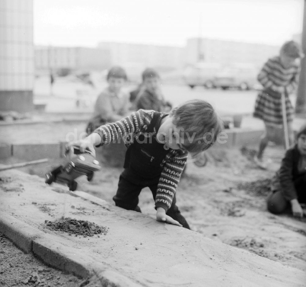 DDR-Bildarchiv: Berlin - Kleiner Junge spielt im Sandkasten mit einem Spielzeugauto in Berlin, der ehemaligen Hauptstadt der DDR, Deutsche Demokratische Republik