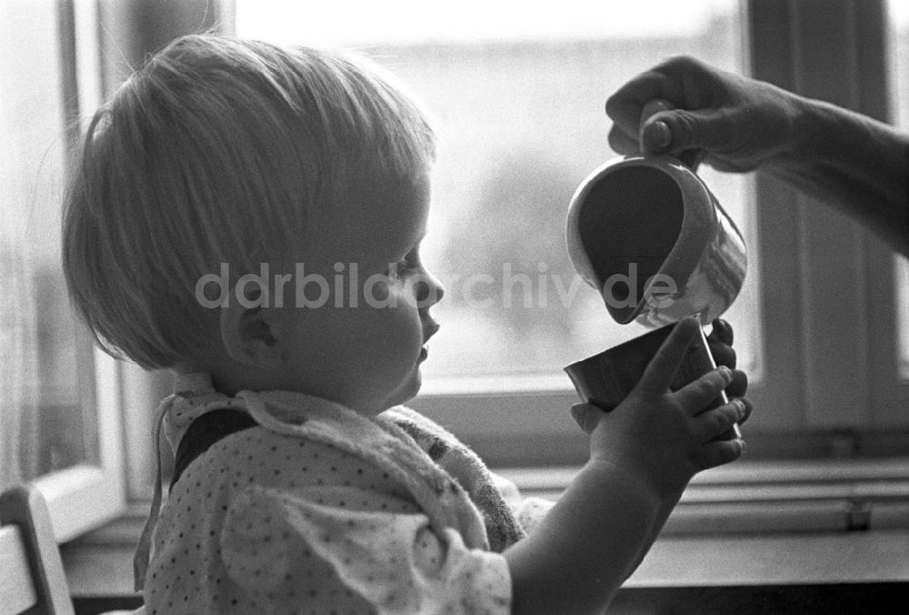 DDR-Fotoarchiv: Berlin - Friedrichshain - Kleines Kind beim trinken aus einer Tasse in Berlin 
