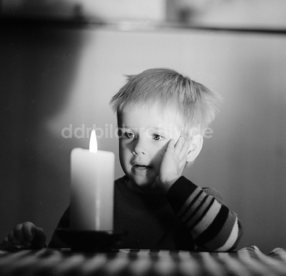 DDR-Bildarchiv: Berlin - Kleines Kind bestaunt eine brennende Kerze die auf einem Tisch steht in Berlin, der ehemaligen Hauptstadt der DDR, Deutsche Demokratische Republik