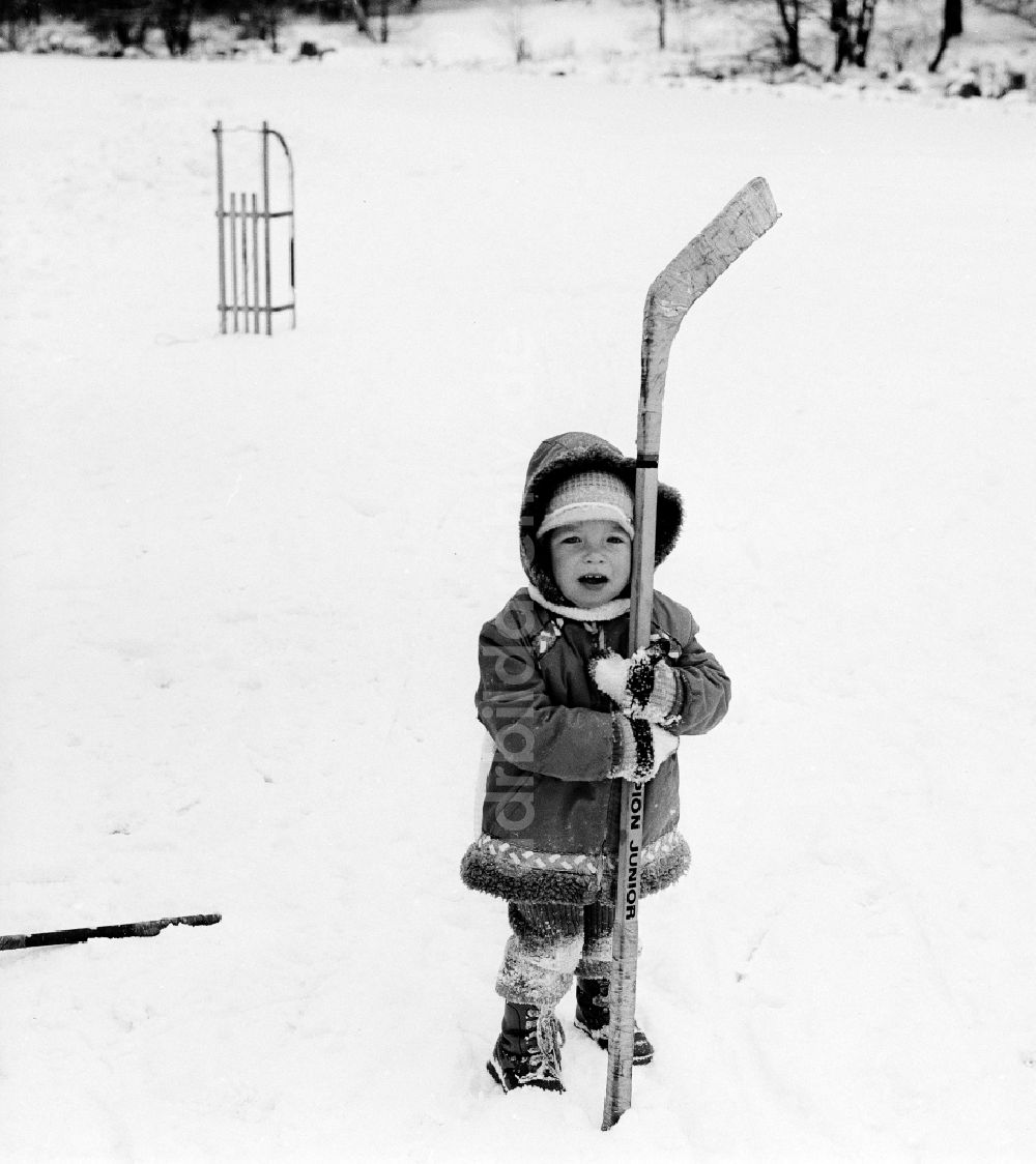 DDR-Fotoarchiv: Wittstock/Dosse - Kleines Kind mit einem Eishockey Schläger in Wittstock/Dosse in Brandenburg in der DDR
