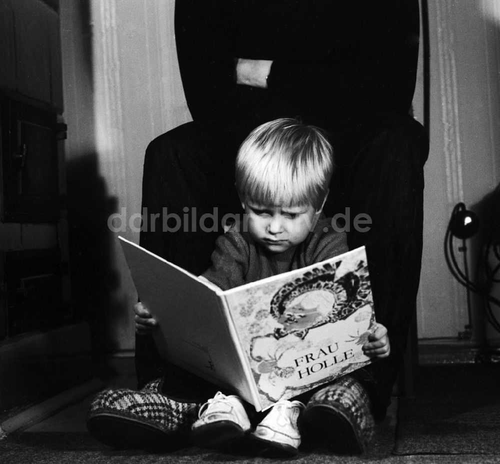 DDR-Fotoarchiv: Berlin - Kleines Kind mit einem Kinderbuch in Berlin, der ehemaligen Hauptstadt der DDR, Deutsche Demokratische Republik