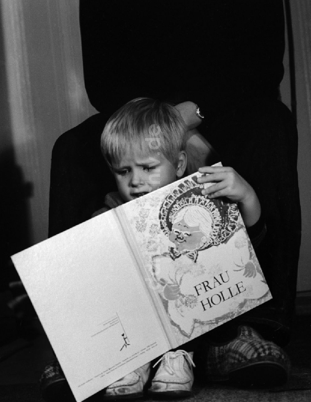 Berlin: Kleines Kind mit einem Kinderbuch in Berlin, der ehemaligen Hauptstadt der DDR, Deutsche Demokratische Republik