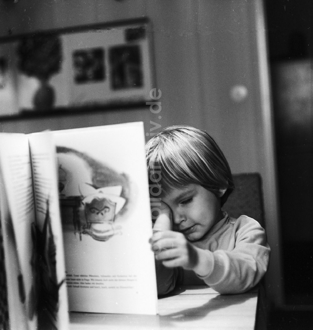 DDR-Fotoarchiv: Berlin - Kleines Kind liest ein Buch in Berlin