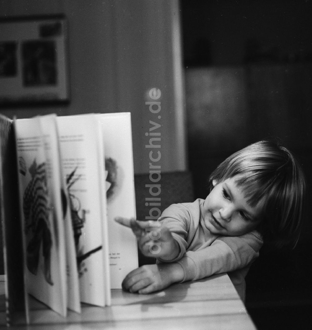 DDR-Bildarchiv: Berlin - Kleines Kind liest ein Buch in Berlin