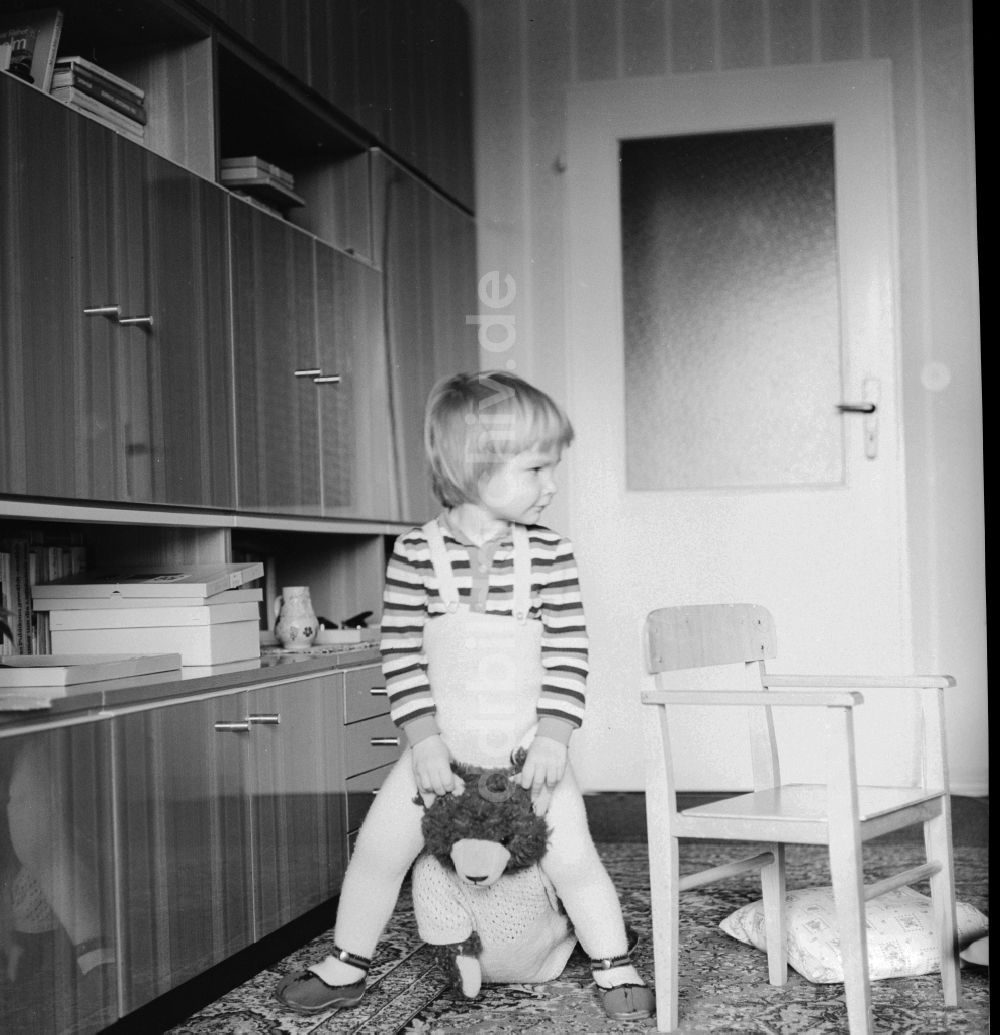 DDR-Fotoarchiv: Berlin - Kleines Kind spielt mit seinem Teddy in Berlin