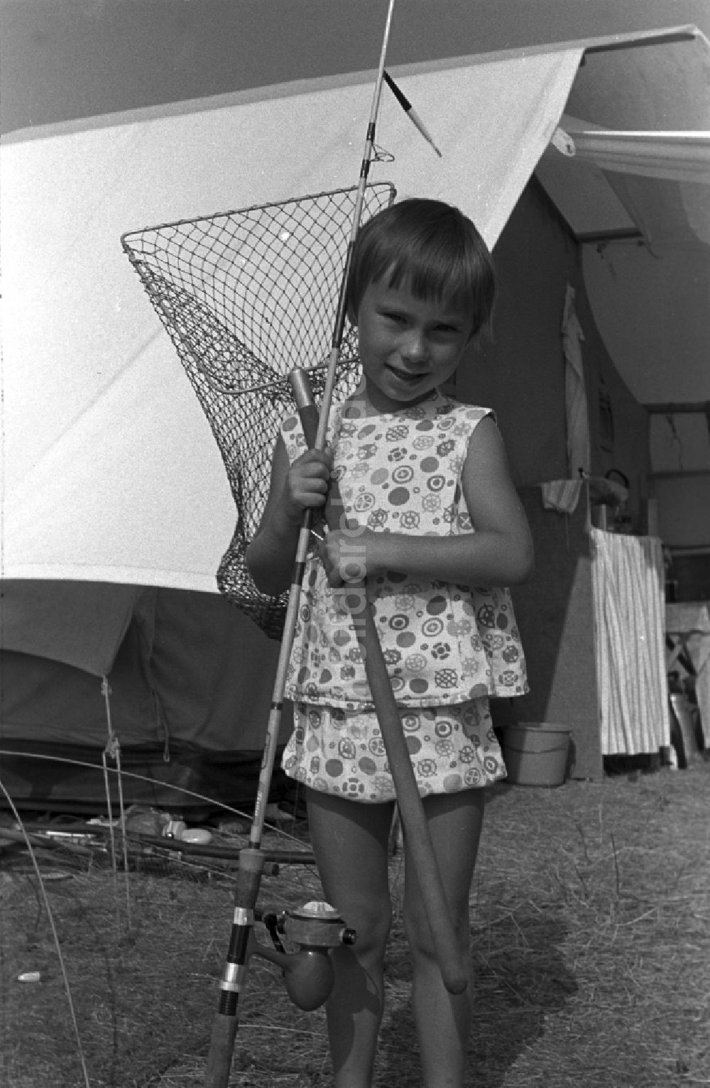 Neuruppin OT Stendenitz: Kleines Mädchen mit Angel und Kescher vor einem Zelt in Brandenburg
