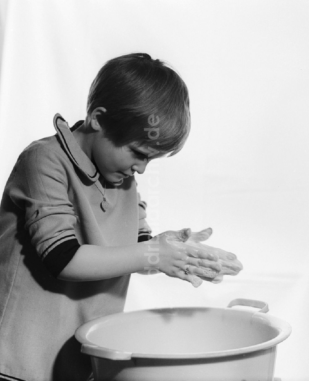 DDR-Bildarchiv: Berlin - Kleines Mädchen beim Hände waschen über einer Plastikschüssel in Berlin
