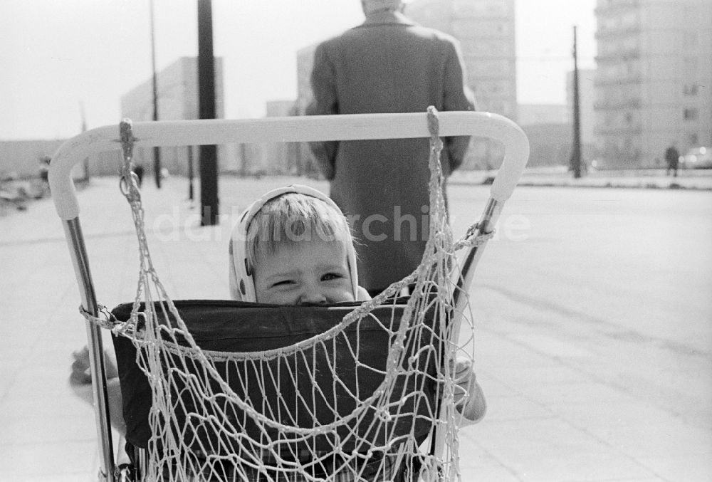 DDR-Bildarchiv: Berlin - Kleines Mädchen mit Kopftuch sitzt in einem Kinderwagen in Berlin, der ehemaligen Hauptstadt der DDR, Deutsche Demokratische Republik