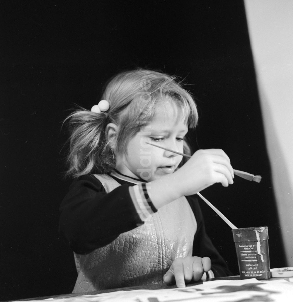 Berlin: Kleines Mädchen mit Zöpfen beim malen mit Pinsel und Tusche in Berlin, der ehemaligen Hauptstadt der DDR, Deutsche Demokratische Republik