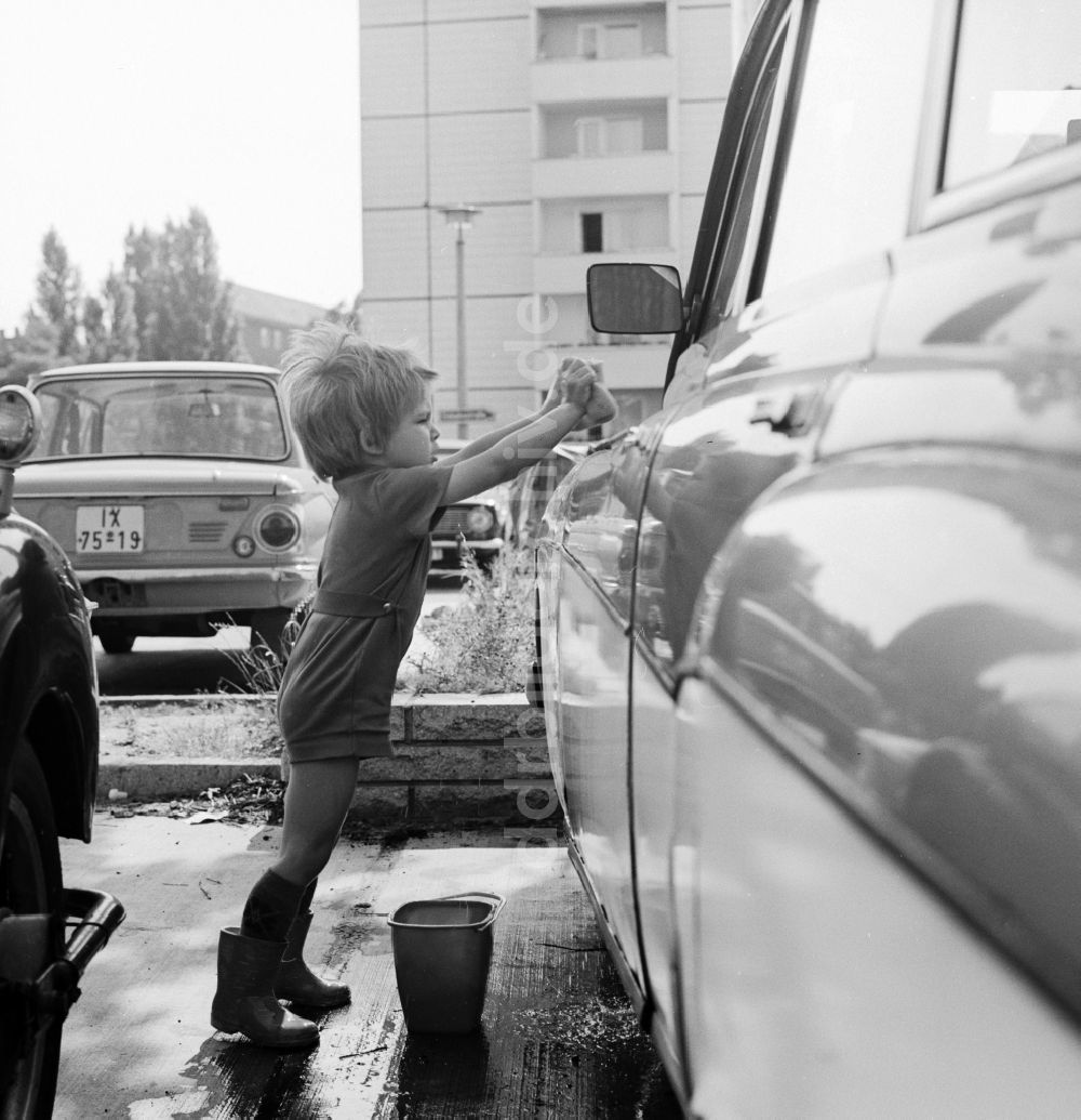 DDR-Bildarchiv: Berlin - Kleinkind beim Auto waschen auf einem Parkplatz in Berlin, der ehemaligen Hauptstadt der DDR, Deutsche Demokratische Republik