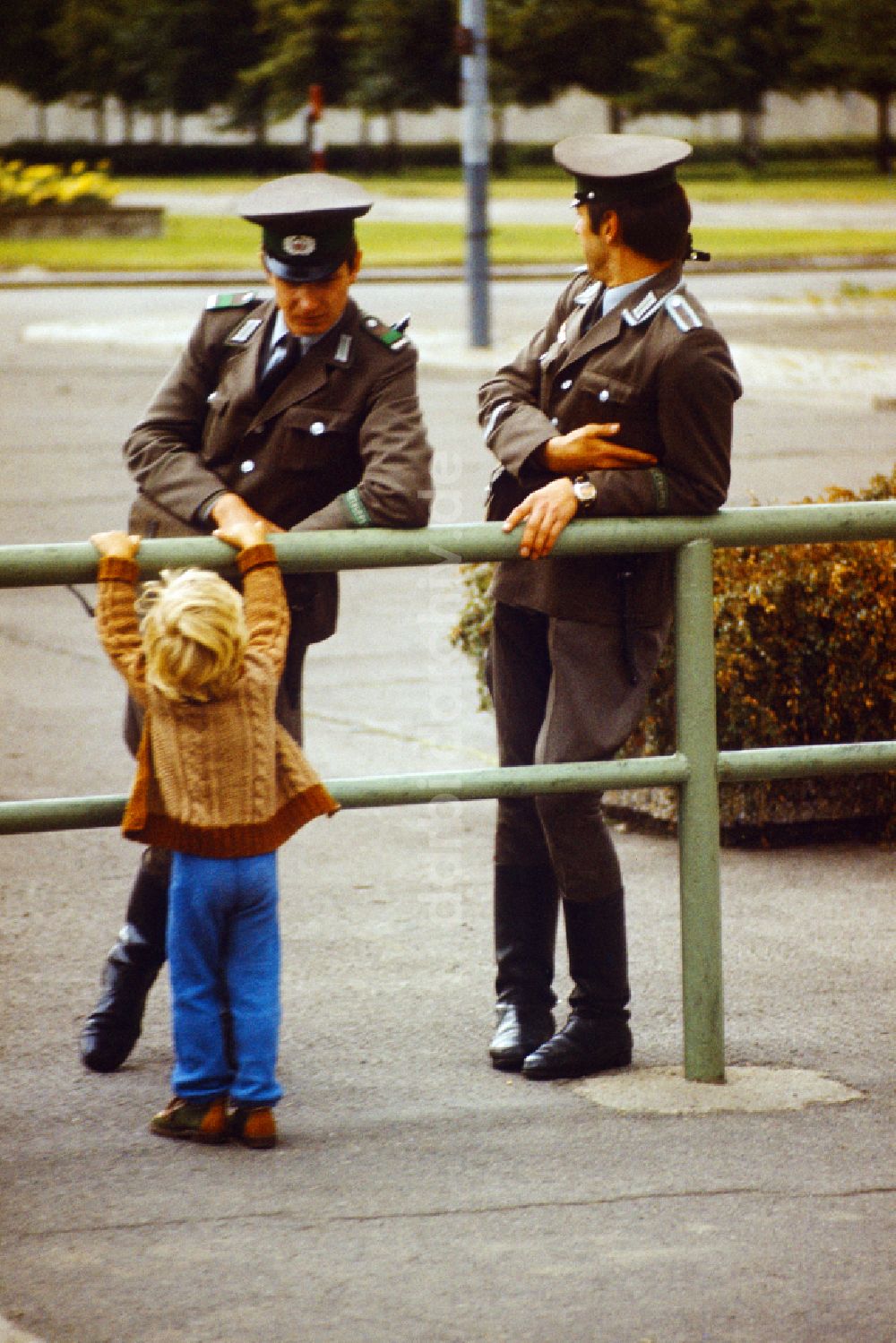 DDR-Fotoarchiv: Berlin - Kleinkind spricht mit Mitgliedern der Grenztruppen der NVA in Osberlin in der DDR