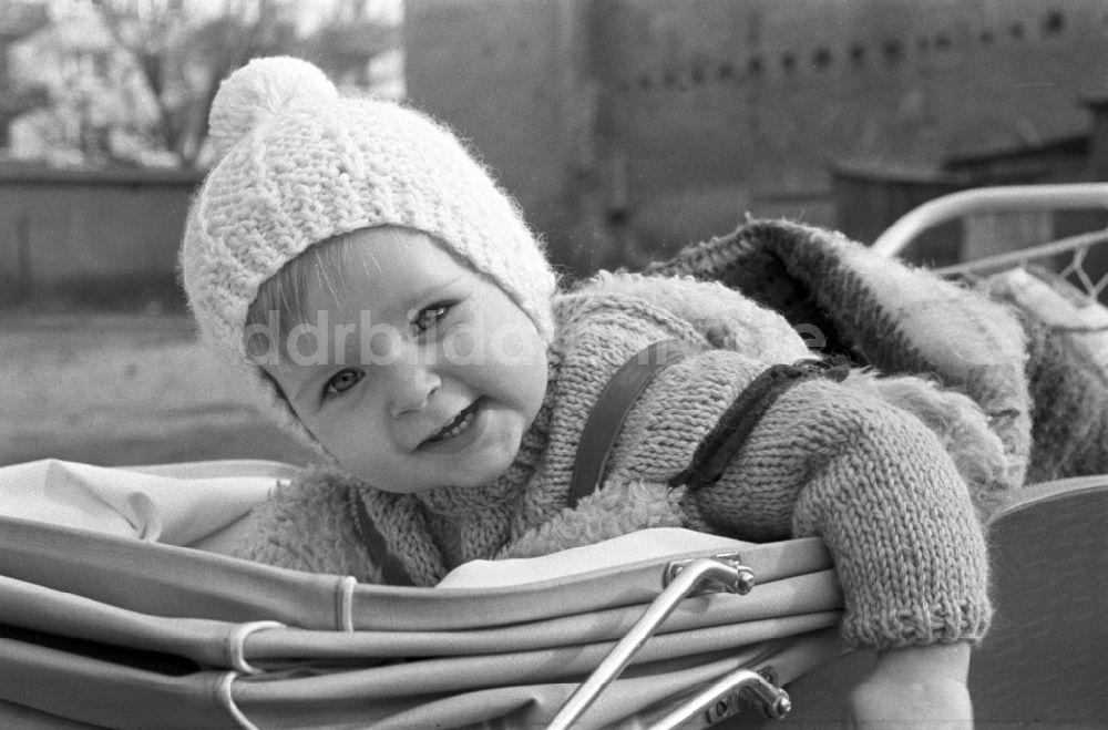 DDR-Fotoarchiv: Magdeburg - Kleinkind mit Strickmütze im Kinderwagen in Magdeburg 