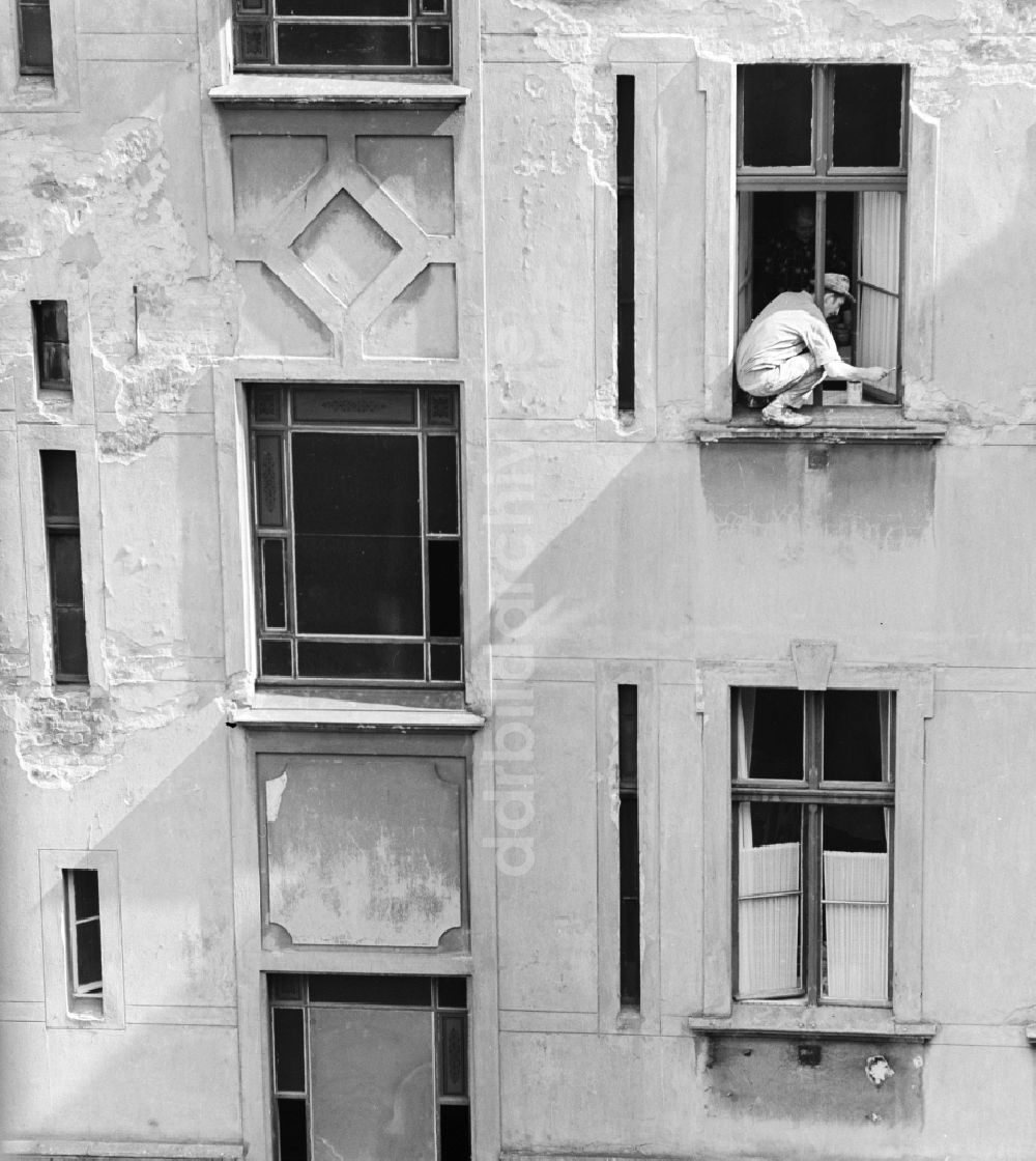 DDR-Fotoarchiv: Berlin - Maler streicht Fenster in einem Hinterhof in Berlin, der ehemaligen Hauptstadt der DDR, Deutsche Demokratische Republik