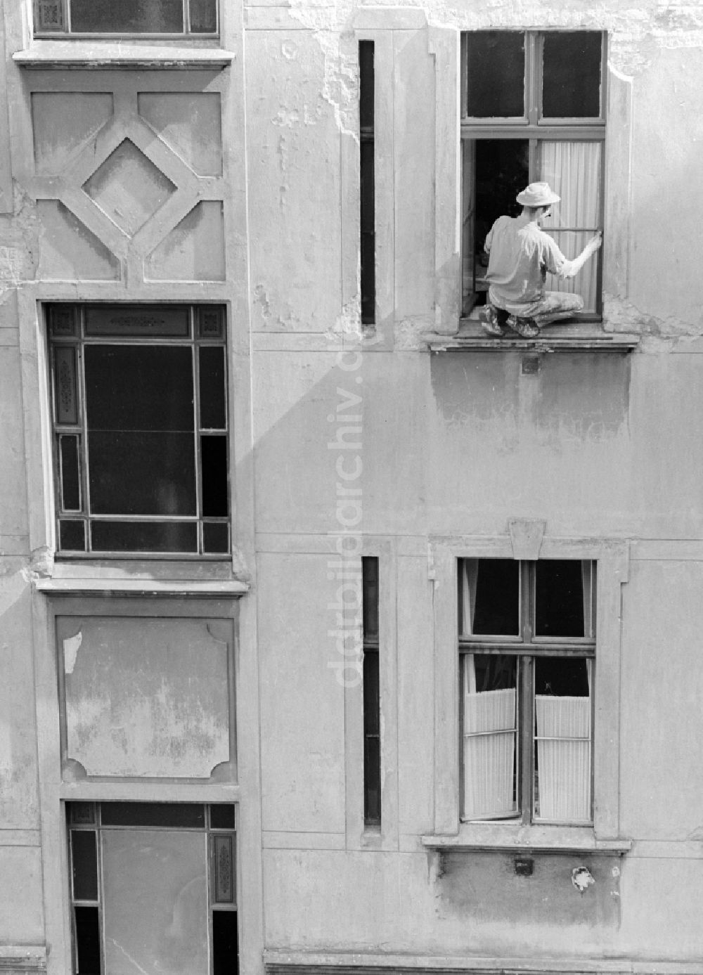 Berlin: Maler streicht Fenster in einem Hinterhof in Berlin, der ehemaligen Hauptstadt der DDR, Deutsche Demokratische Republik