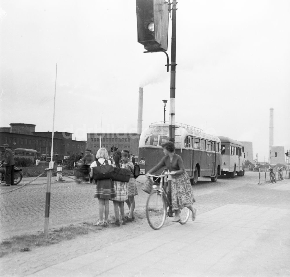 Schkopau: Mädchen mit Schulranzen stehen am Straßenrand und beobachten den Straßenverkehr in Schkopau in Sachsen-Anhalt in der DDR