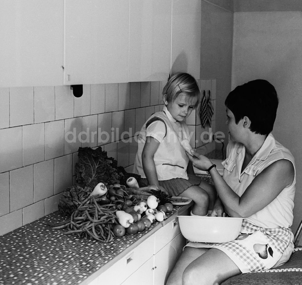 DDR-Fotoarchiv: Berlin - Friedrichshain - Mutter mit Kind in der Küche beim Gemüse putzen in Berlin - Frierichshain