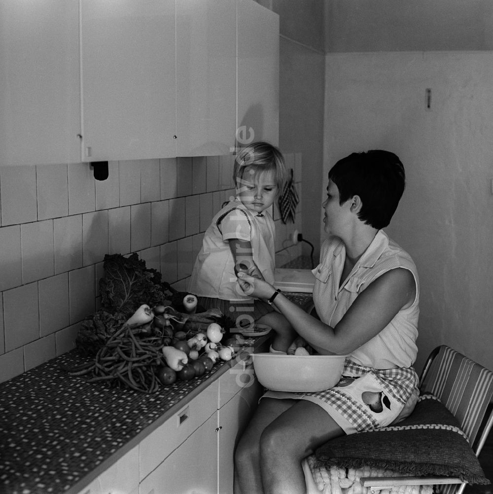 Berlin - Friedrichshain: Mutter mit Kind in der Küche beim Gemüse putzen in Berlin - Frierichshain