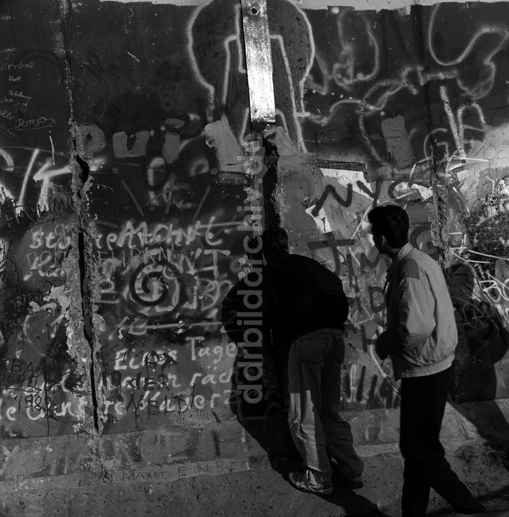 DDR-Bildarchiv: Berlin - Neugierig schauen Touristen und Berliner durch ein Loch in der Berliner Mauer 