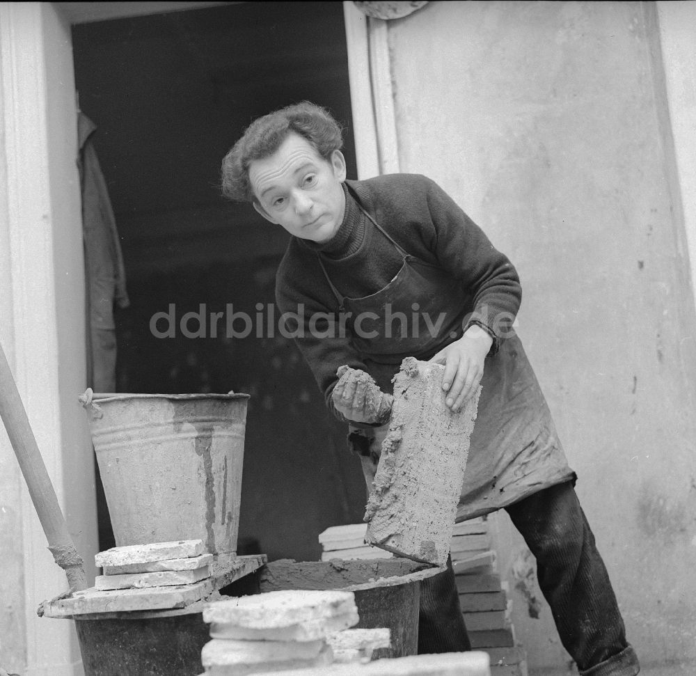 Frankfurt (Oder): Ofensetzer beim Aufstellen eines Kachelofen in Frankfurt (Oder) in Brandenburg in der DDR