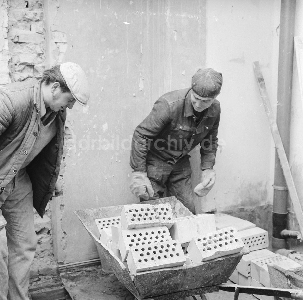 Frankfurt (Oder): Ofensetzer beim Aufstellen eines Kachelofen in Frankfurt (Oder) in Brandenburg in der DDR