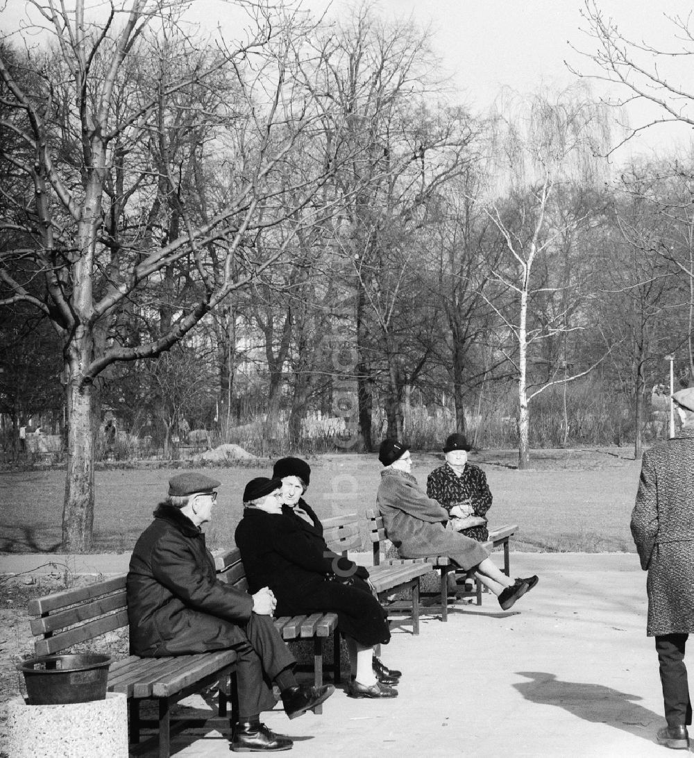 Berlin: Rentner sitzen auf Parkbänken im Volkspark Friedrichshain und geniessen die ersten Sonnenstrahlen im Frühling in Berlin, der ehemaligen Hauptstadt der DDR, Deutsche Demokratische Republik