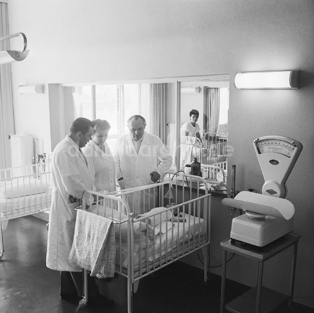 DDR-Bildarchiv: Borna - Ärzte / Kinderärzte stehen vor Babybett auf der Kinderstation im Kreiskrankenhaus Borna
