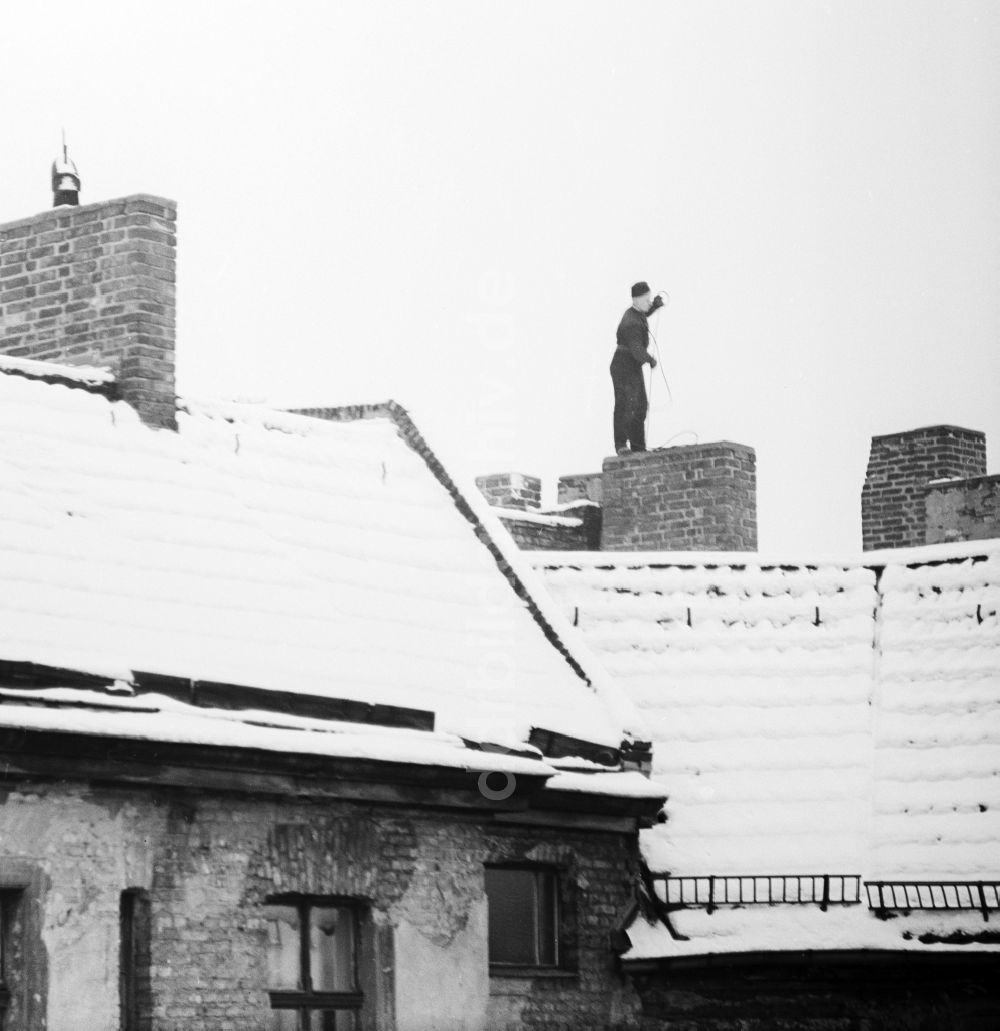 DDR-Bildarchiv: Berlin - Schornsteinfeger auf schneebedeckten Dächern bei der Arbeit in Berlin, der ehemaligen Hauptstadt der DDR, Deutsche Demokratische Republik