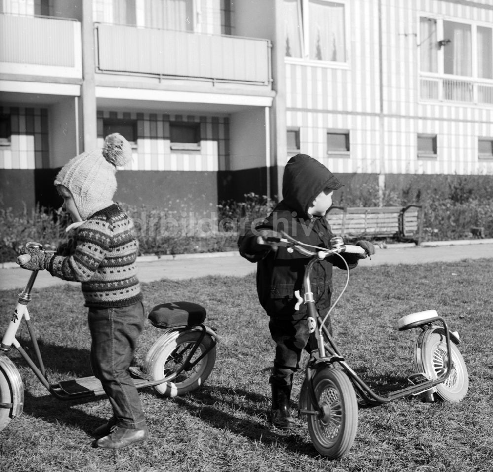 DDR-Bildarchiv: Berlin - Spielende Kinder mit ihren luftbereiften Rollern in einem Innenhof eines Wohngebietes in Berlin, der ehemaligen Hauptstadt der DDR, Deutsche Demokratische Republik