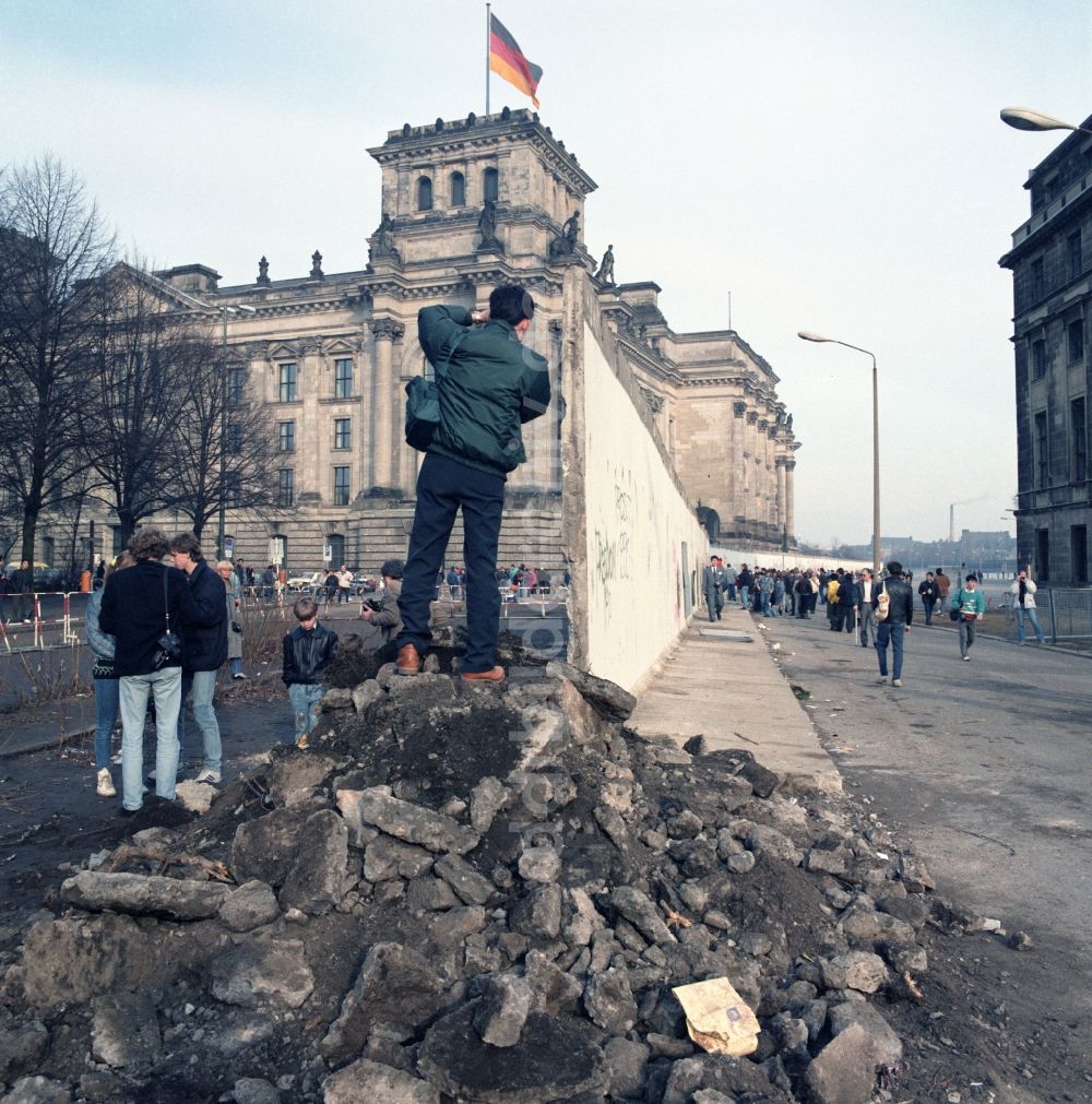 Berlin: Touristen und Berliner Bürger besichtigen den Abriss der Berliner Mauer am Reichstagsgebäude in Berlin
