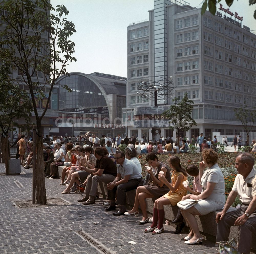 DDR-Fotoarchiv: Berlin - Mitte - Touristen sitzen an der Weltzeituhr vor dem S-Bahnhof Alexanderplatz in Berlin - Mitte