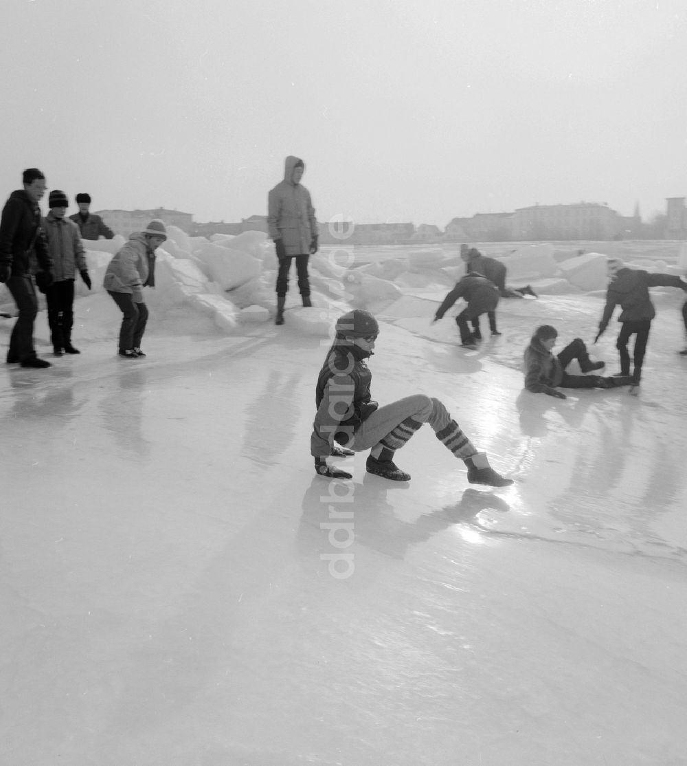 DDR-Bildarchiv: Warnemünde - Touristen spazieren auf der zugefrorenen und schneebedeckten Ostsee in Warnemünde in Mecklenburg Vorpommern in der DDR