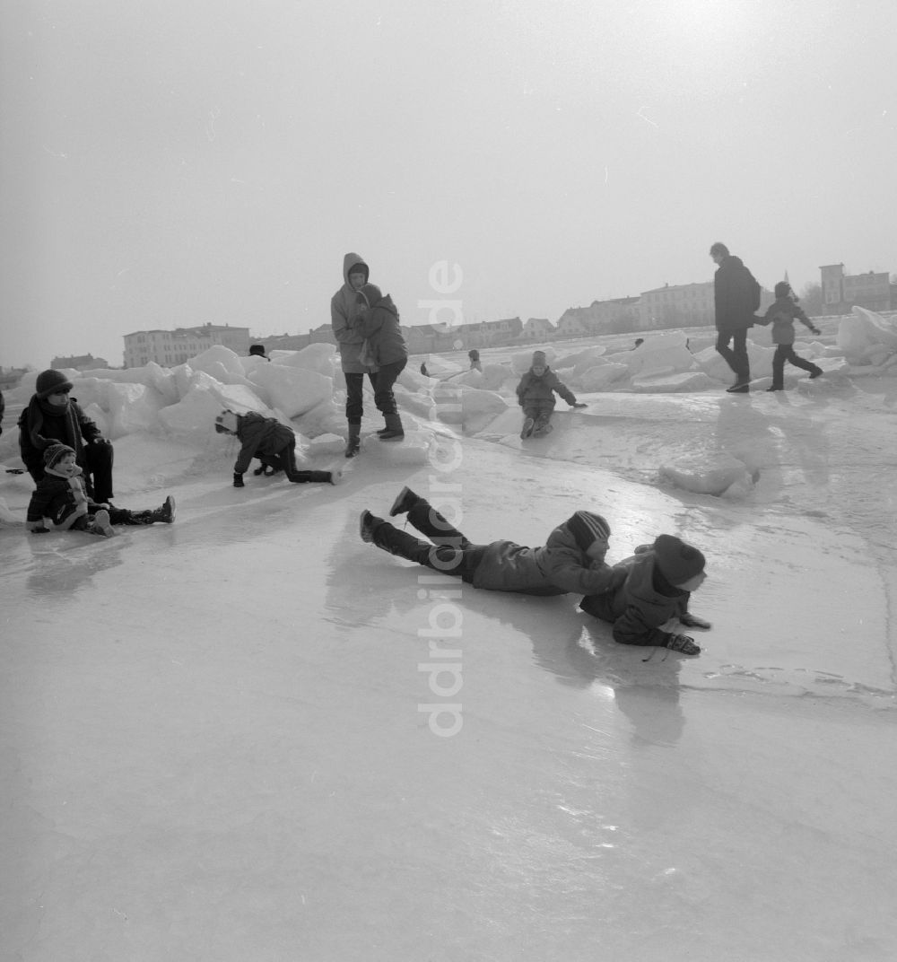 DDR-Fotoarchiv: Warnemünde - Touristen spazieren auf der zugefrorenen und schneebedeckten Ostsee in Warnemünde in Mecklenburg Vorpommern in der DDR