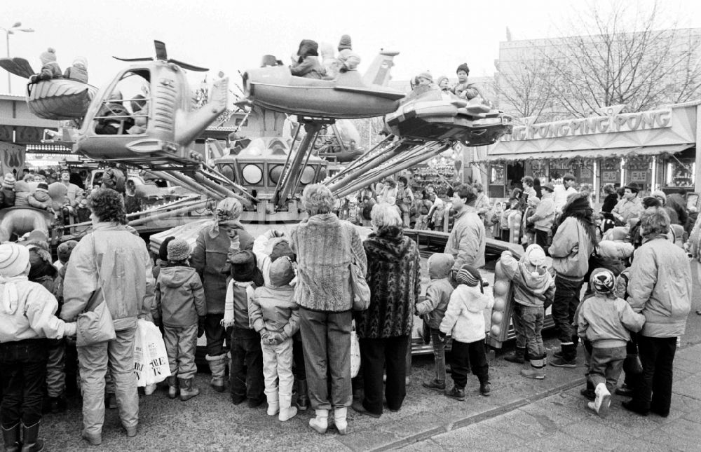 DDR-Fotoarchiv: Berlin - Weihnachtsmarkt mit Kindern in einem Fahrzeug- Karussel in Berlin in der DDR