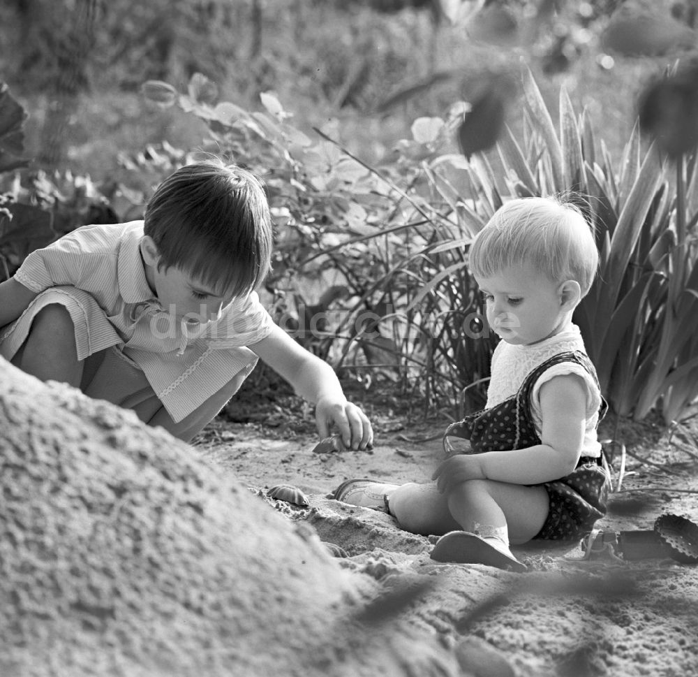 DDR-Fotoarchiv: Warnemünde - Zwei Kinder beim spielen im Sand in Warnemünde in Mecklenburg - Vorpommern